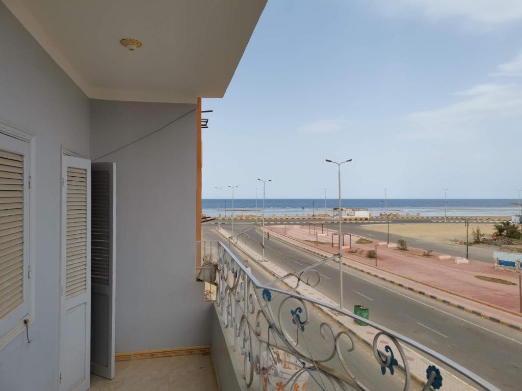 a room with a balcony with a view of the beach at Qussier sea view apartment in Quseir
