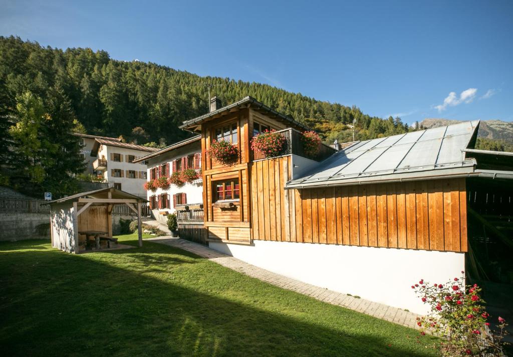 a building with a roof with flowers on it at Chasa Allegra Müstair in Müstair