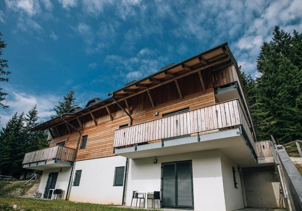 ein Haus mit einer Terrasse darüber in der Unterkunft Apartma EVA Golte in Mozirje