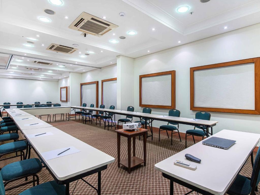 a room with rows of tables and chairs at Hotel Cassino Tower Campinas Cambuí By Nacional Inn in Campinas