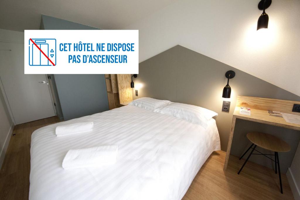 - une chambre avec un lit et un panneau indiquant que l'hôtel ressemble à un ambassadeur dans l'établissement Brit Hotel Essentiel Arverne - Clermont-Ferrand Sud, à Aubière