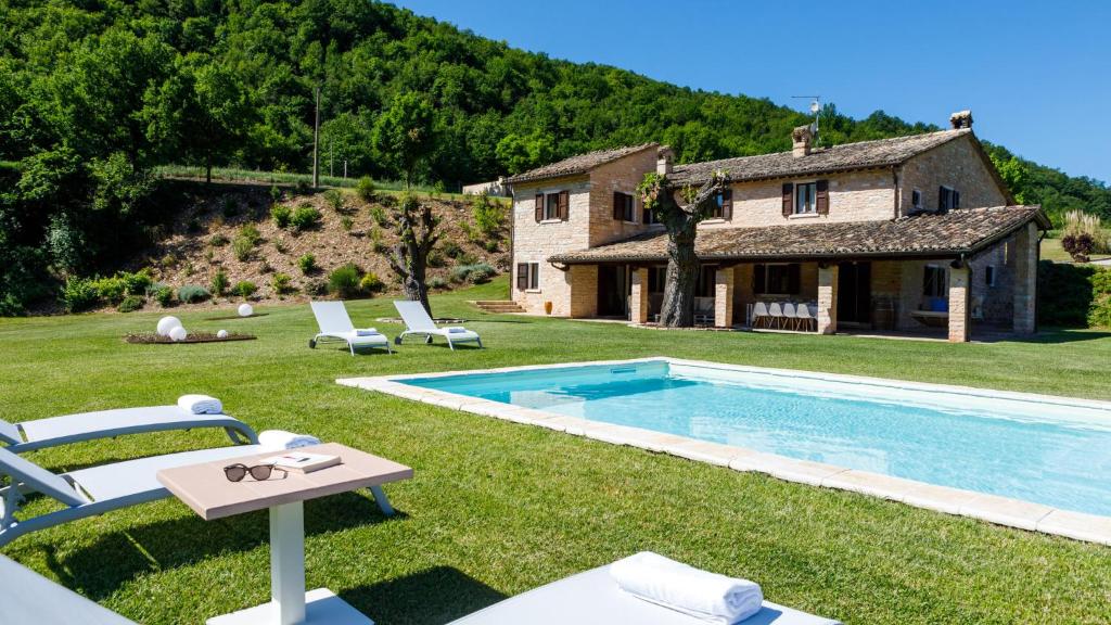 a backyard with a pool and a house at Villa Poderina 8, Emma Villas in Acqualagna
