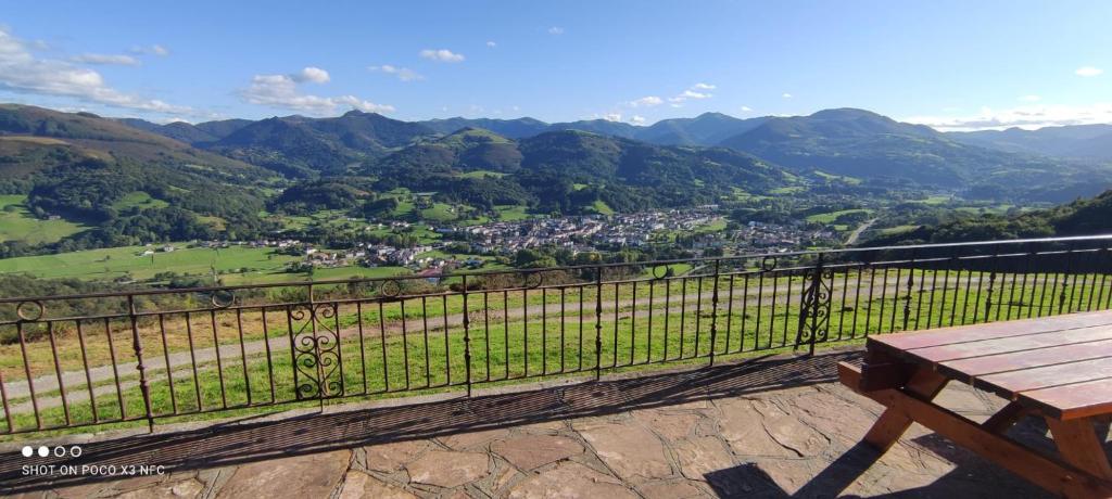 a view of a valley with a bench and mountains at Autxikoborda in Elbete