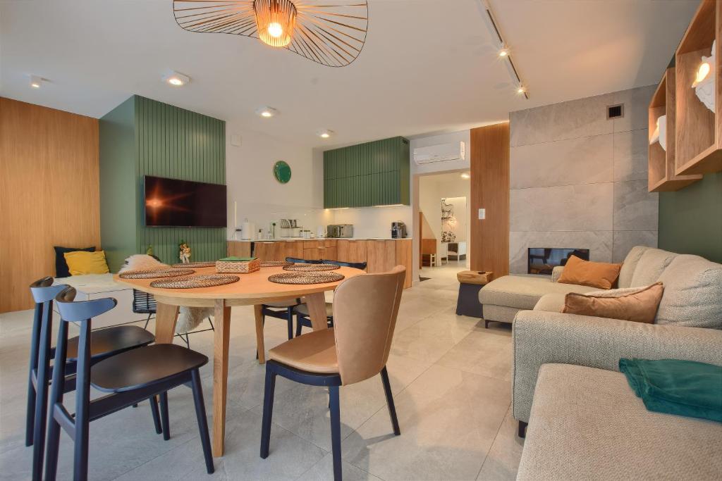 Il comprend une cuisine et un salon avec une table et des chaises. dans l'établissement Sun&Sport Apartament FOREST prywatna sauna w cenie, à Szczyrk