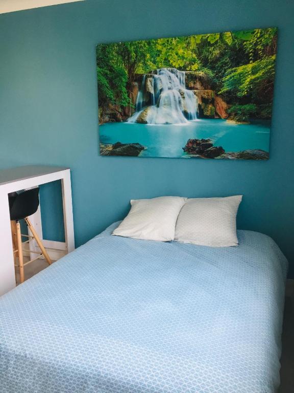 - une chambre avec un lit orné d'une peinture murale représentant une cascade dans l'établissement Studio 2 bien agencé et tout équipé, à Lorient