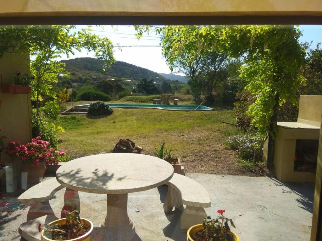 a patio with a table and a view of a pool at Piccolina, casa en las sierras de Cba. in Unquillo