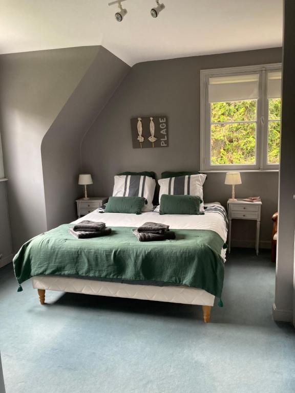 a bedroom with a large bed with green sheets at Les Glycines in Croix