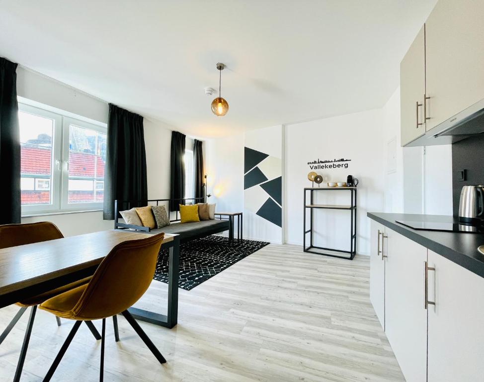 uma cozinha e sala de estar com mesa e cadeiras em City Apartments Grendelplein em Valkenburg