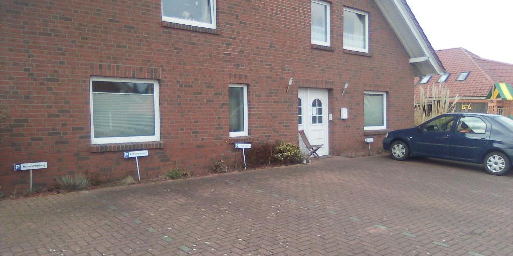 a car parked in front of a brick house at FeWo Baltrum in Roggenstede in Dornum