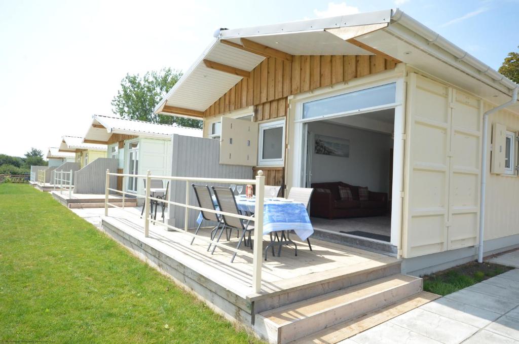 ein Haus mit einer Terrasse mit einem Tisch in der Unterkunft Premium Lake Lodges in Chichester