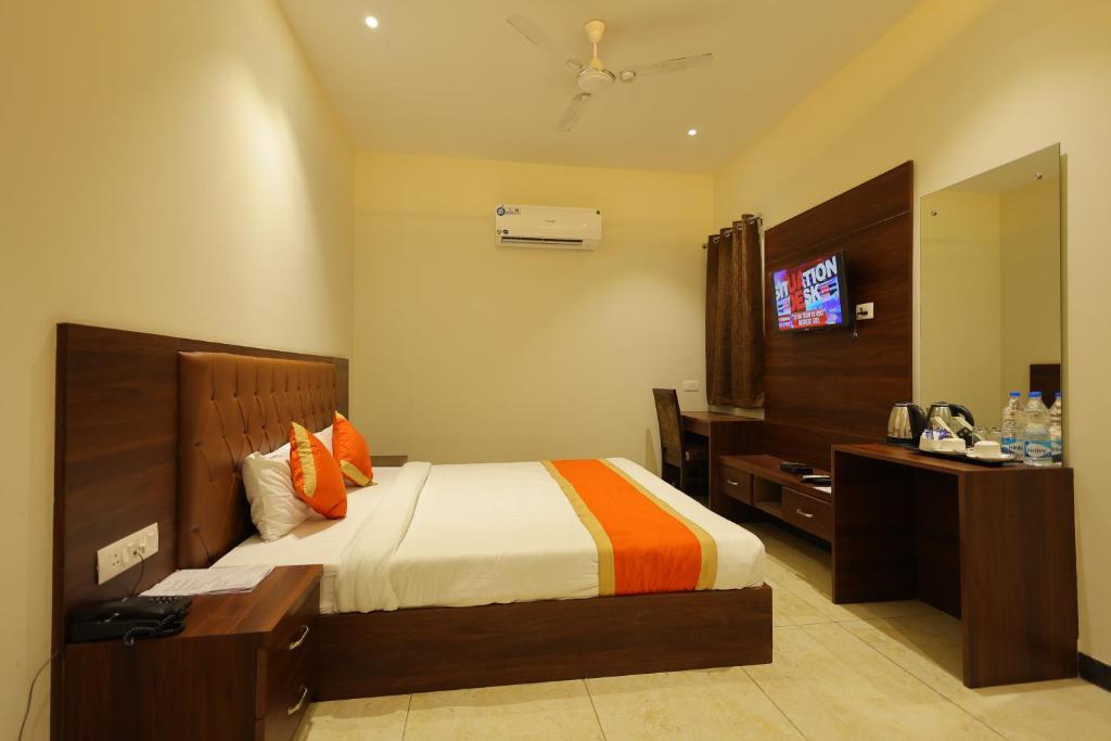 a bedroom with a bed and a television in it at The Grand Tree Hotel in Agra