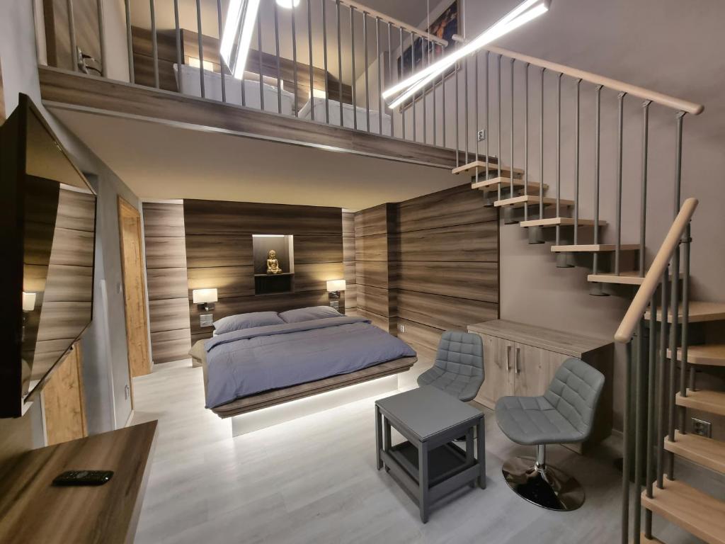 a bedroom with a bed and a staircase at Apartmány Etenia in Kadaň