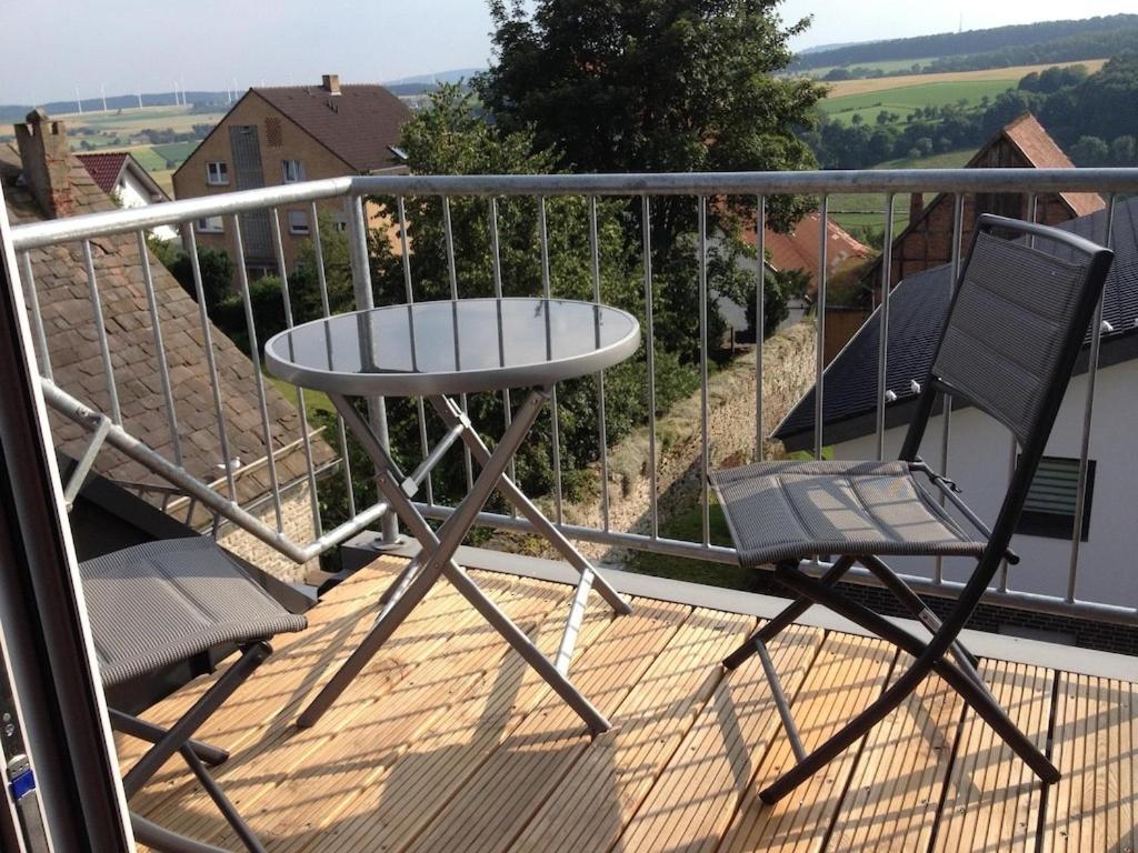 einen Balkon mit 2 Stühlen und einem Tisch auf einer Terrasse in der Unterkunft Feriendomizil Ösetalblick in Bad Driburg