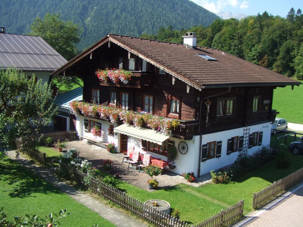 une maison avec des fleurs sur son côté dans l'établissement Krennlehen, à Schönau am Königssee