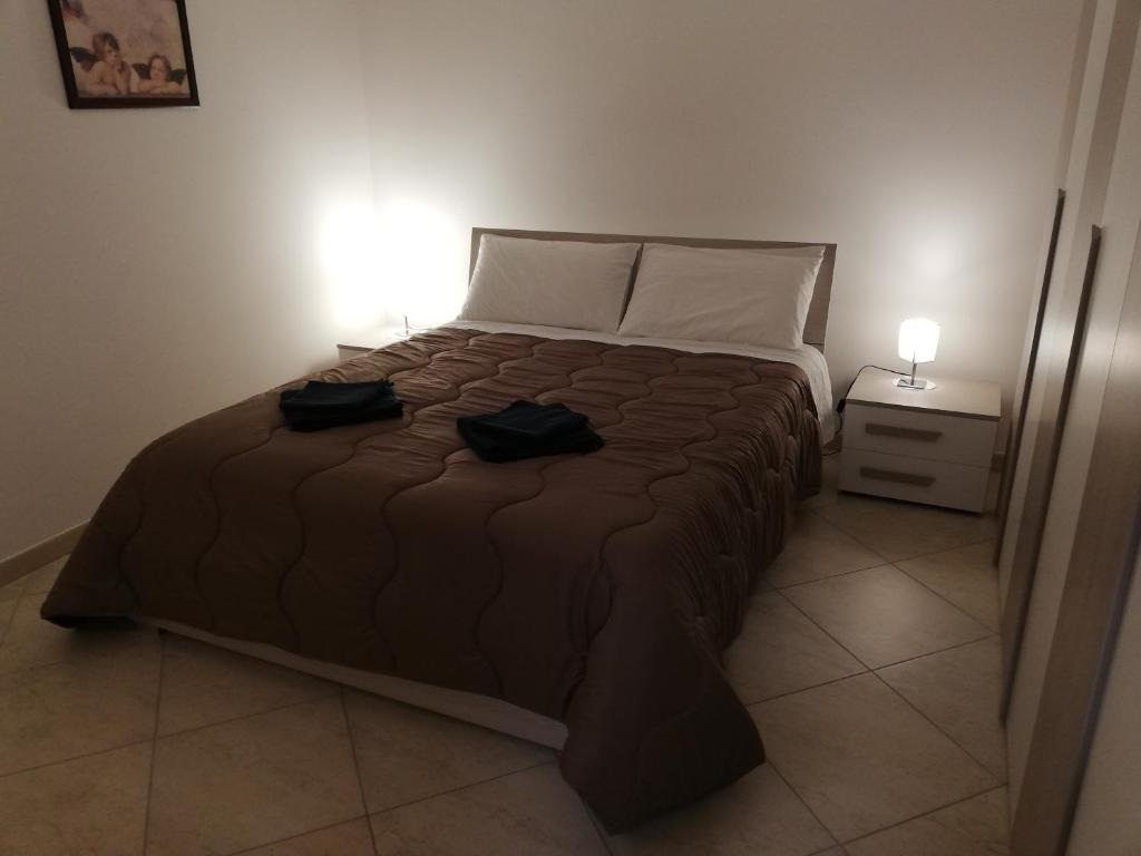 sypialnia z łóżkiem z dwoma czarnymi butami w obiekcie Levante waterfront w mieście Bari