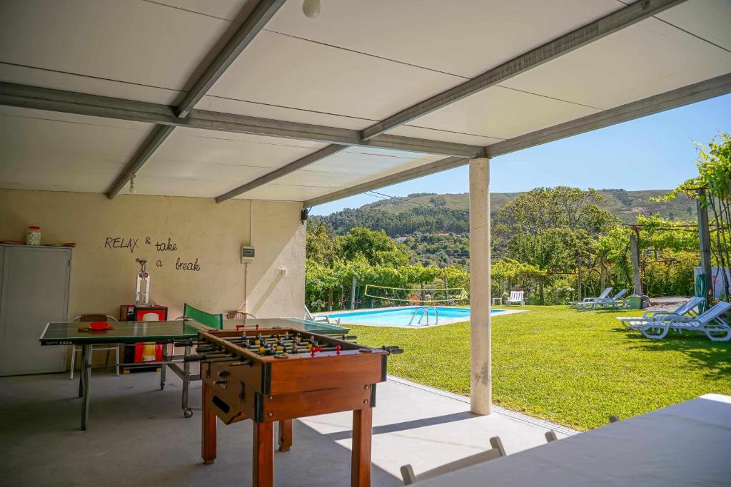 um quarto com uma mesa de pingue-pongue e uma piscina em Casa do Cabo Ponte de Lima em Ponte de Lima