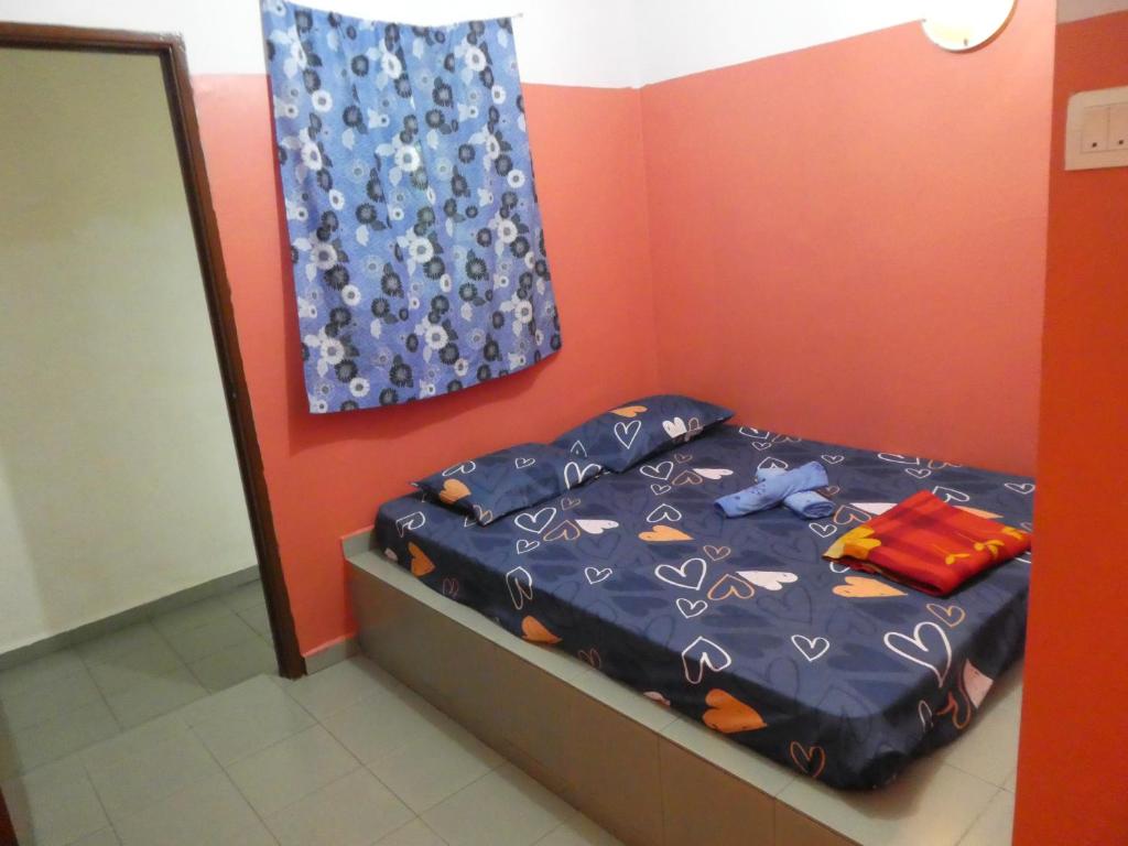 a bedroom with a bed with a blue comforter at TIT MOTEL in Sungai Petani