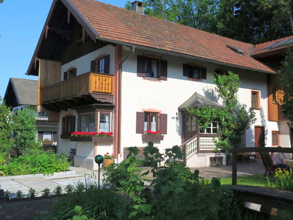 uma grande casa branca com uma varanda em Ferienwohnung Aiblinger em Frasdorf