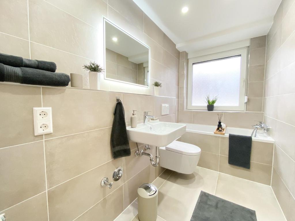 a bathroom with a sink and a toilet and a mirror at Apartment Mozart in Gernsbach