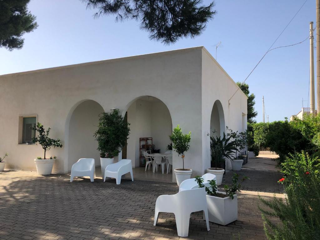 マルッジョにあるVilla Luciaの白い椅子と鉢植えの白い建物