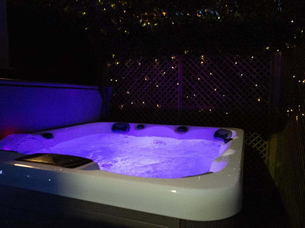 a purple bath tub in a room with lights at The Gathering @ Liver House - Hot Tub - Near Liverpool - Sleeps Up To 20 in Rock Ferry