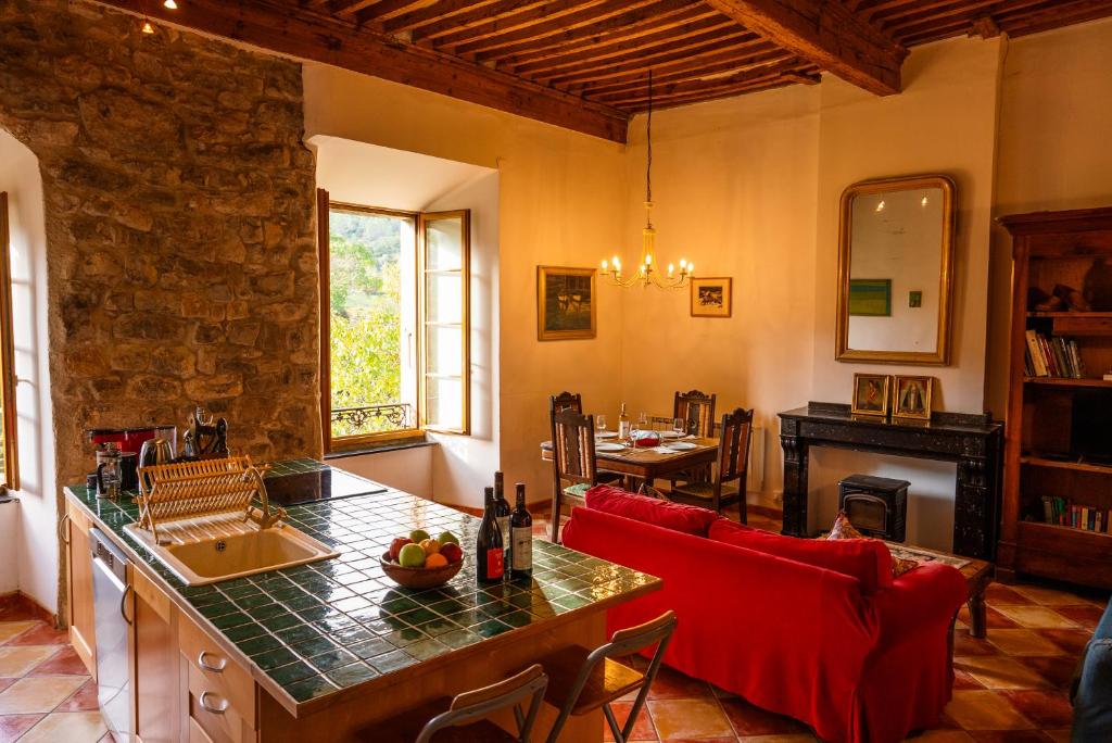 sala de estar con sofá rojo y mesa en The Riverside Gîte Lagrasse, en Lagrasse