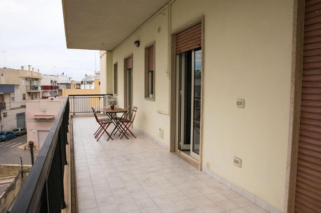 balkon domu ze stołem i krzesłami w obiekcie Cà del Mar w mieście Polignano a Mare