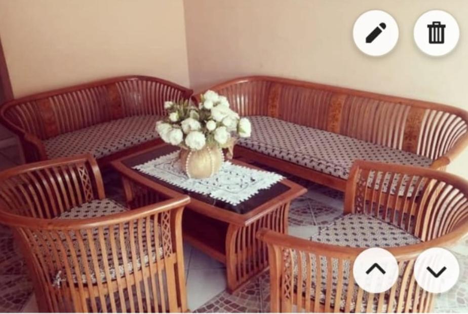 a table and chairs with a vase of flowers on it at Résidence Lina in Libreville
