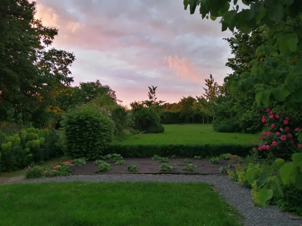 a view of a garden at sunset at La Ferme aux Charmes in Solre-le-Château