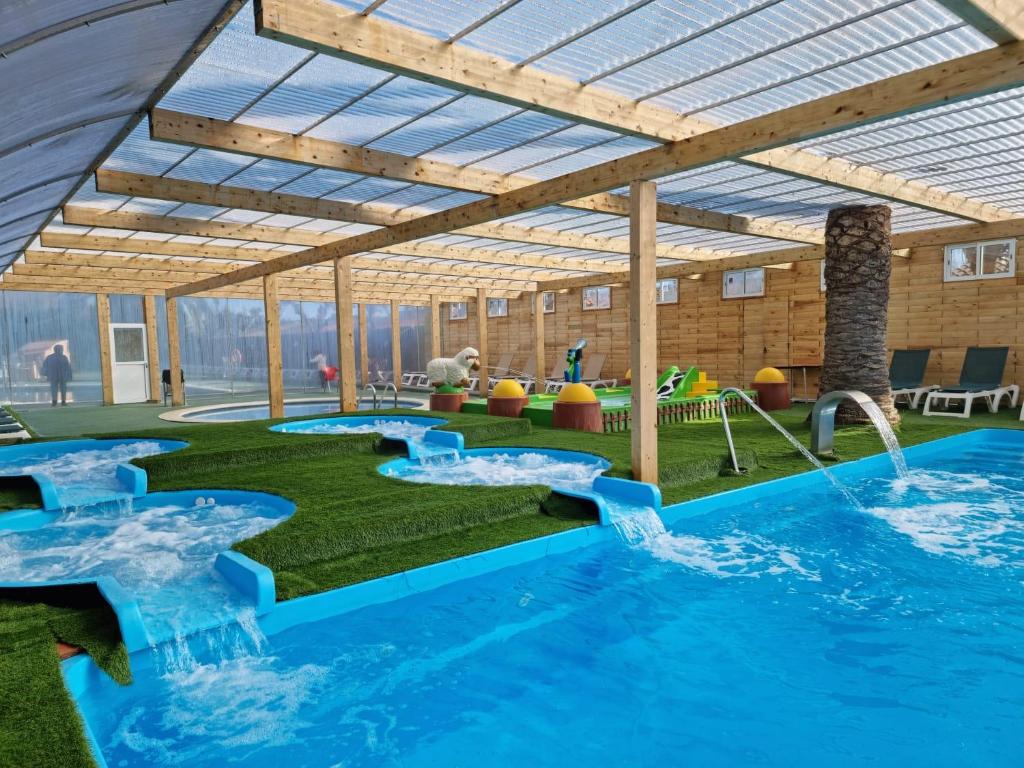 a large swimming pool with two slides in the middle at Mediterrani Natura Spa Resort in Tarragona