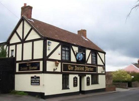 un bâtiment blanc et noir avec un panneau sur lequel figure un panneau dans l'établissement The Ancient Mariner, à Nether Stowey