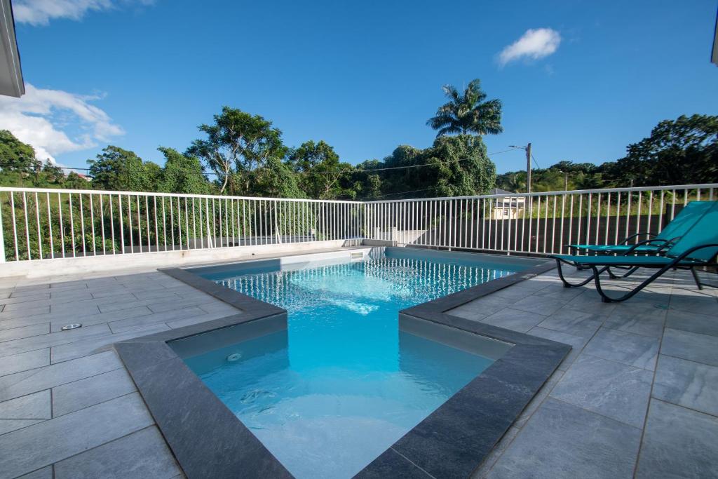 een zwembad met een stoel naast een hek bij Caribbean’ZEN in Petit-Bourg