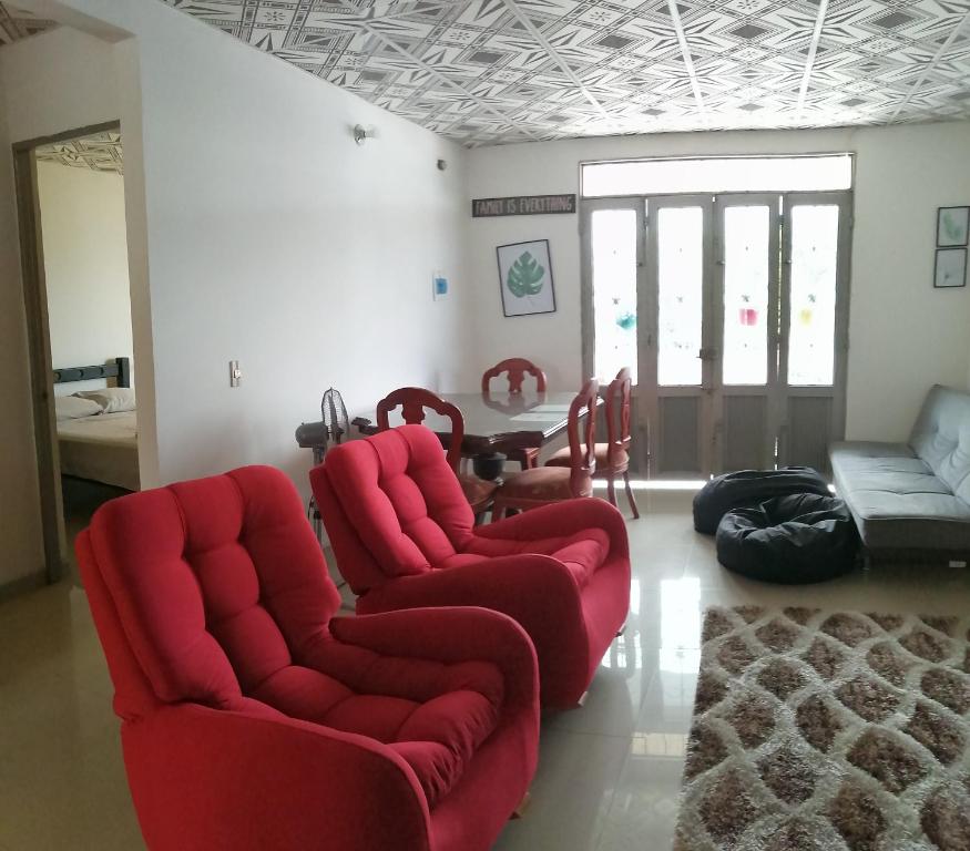 een woonkamer met 2 rode stoelen en een tafel bij Apartamento Iwoo Hr in Villavicencio