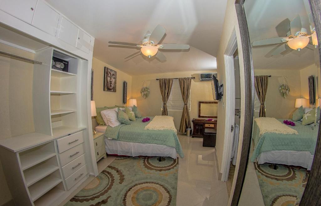 a bedroom with two beds and a ceiling fan at Lantana Barbados Condos in Saint James