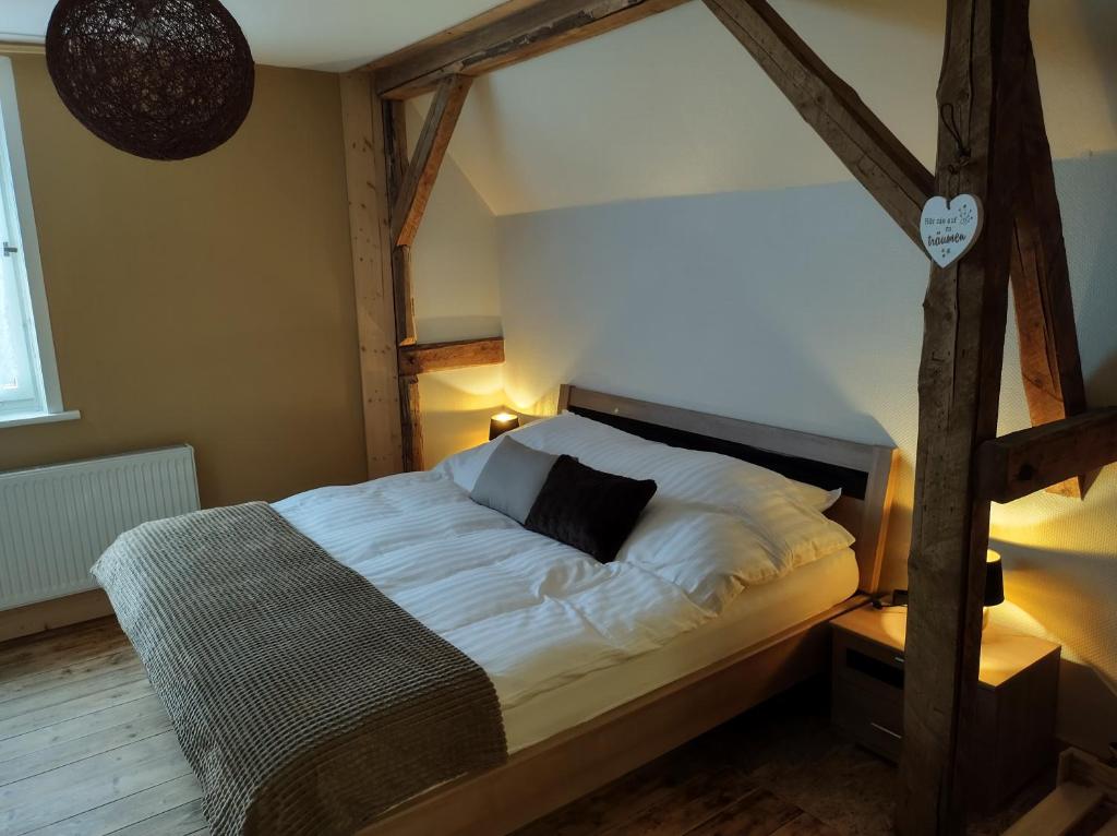 a bedroom with a large bed with a wooden headboard at Minicamping und B&B Apartment Hintergarten in Niederorschel