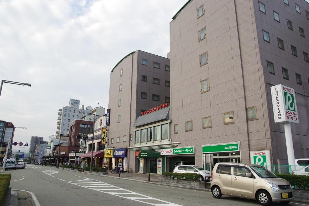 un coche aparcado en una calle en una ciudad en Hida Takayama Washington Hotel Plaza en Takayama