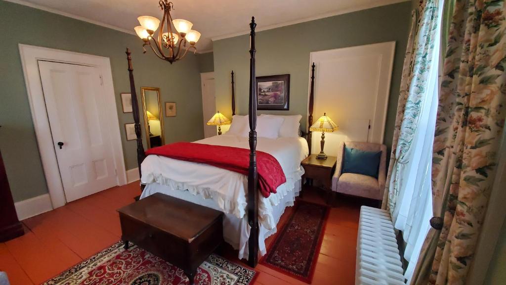 a bedroom with a bed and a chandelier at The Lark & Loon Inn in Annapolis Royal