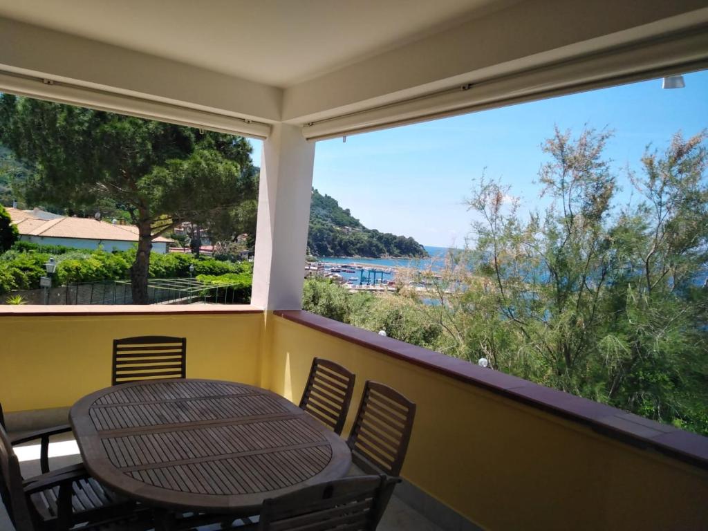 un tavolo e sedie su un balcone con vista sull'oceano di Casa Vacanze De Simone San Marco di Castellabate a Castellabate