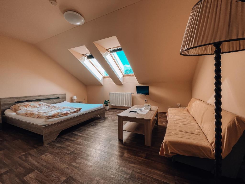 1 dormitorio con cama, sofá y mesa en Penzion Na Vošverku, en Čelákovice