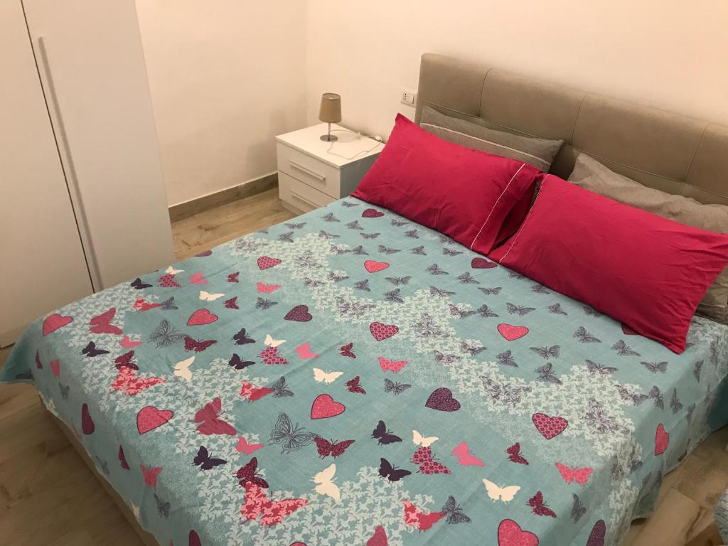 a bed with a blue comforter with hearts on it at Casa Tonino in Porto Cesareo