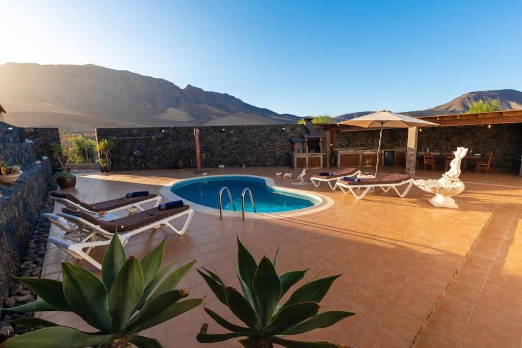 eine Terrasse mit Swimmingpool und Liegestühlen in der Unterkunft Villa Sara Fuerteventura in Cardón