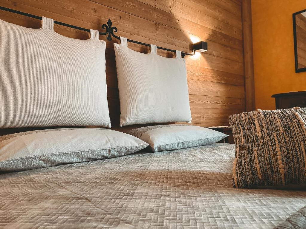 ein Schlafzimmer mit einem Bett mit weißen Kissen in der Unterkunft Apartment L'Envers in Aosta
