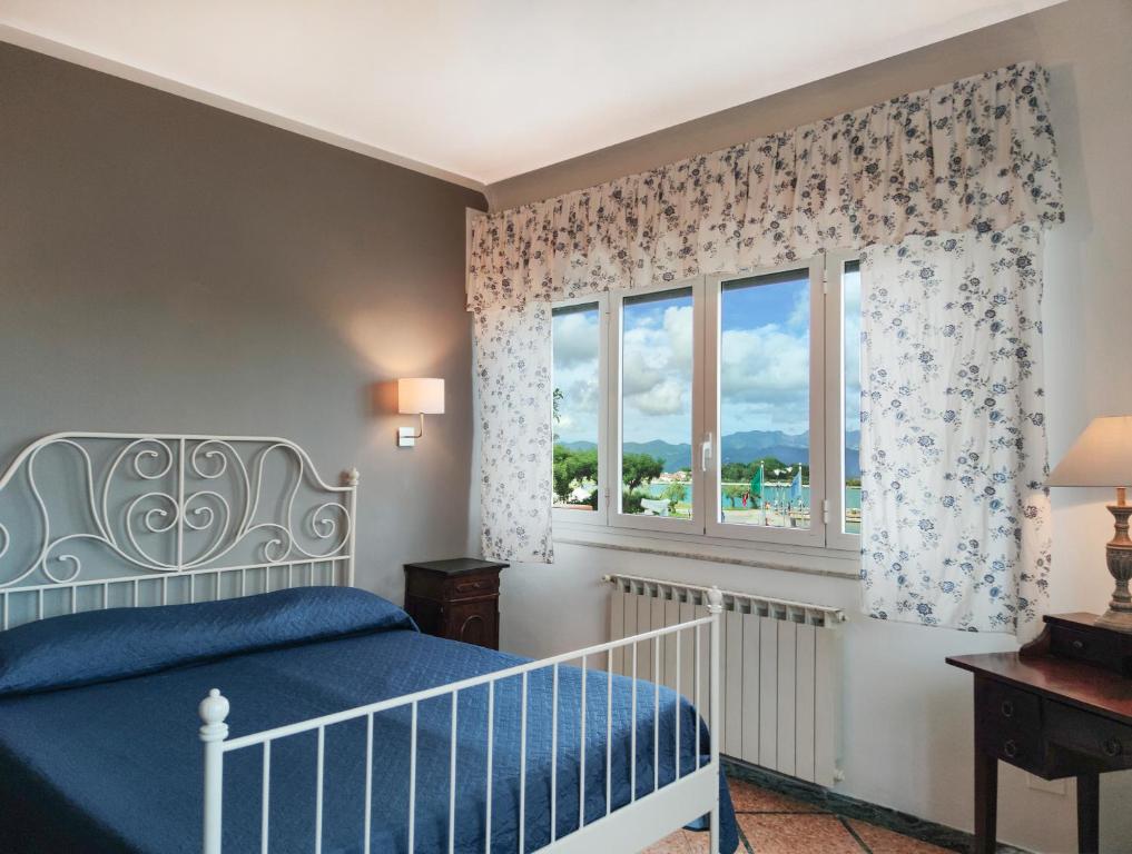 a bedroom with a blue bed and a window at Hotel Sette Archi in Bocca di Magra