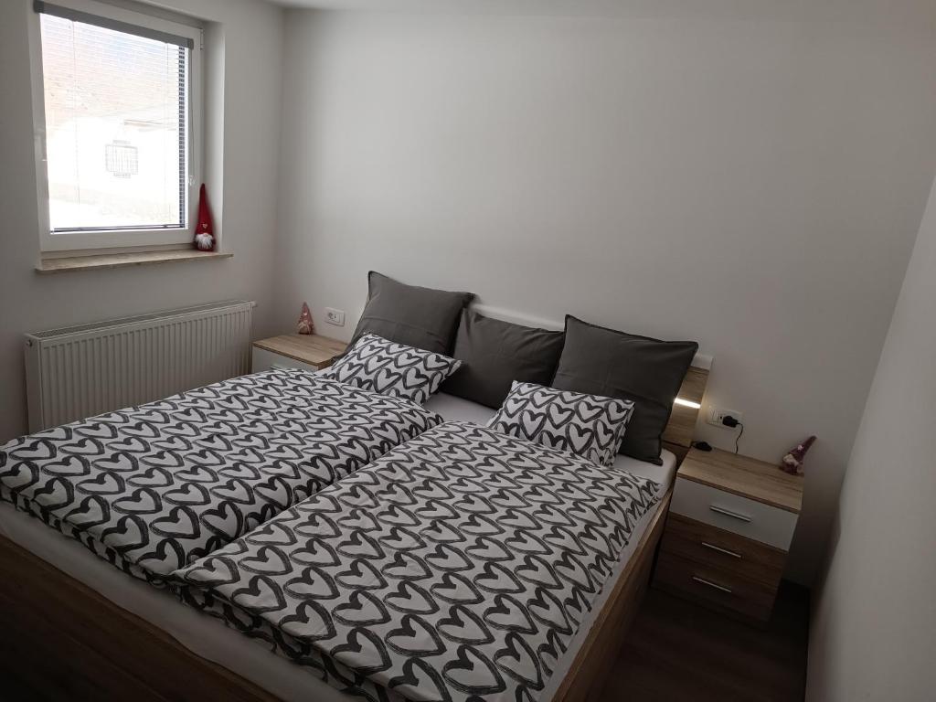 1 dormitorio con 1 cama con edredón blanco y negro en Apartments Mici, en Bled