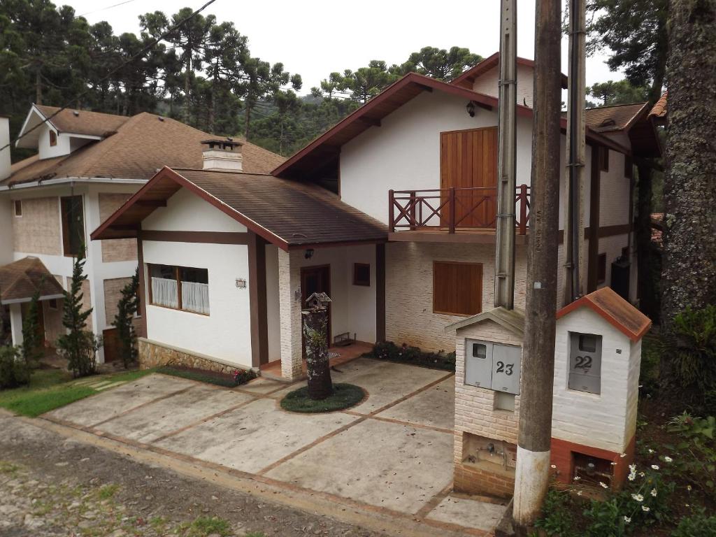 uma casa com um alimentador de aves em frente em Casa MARAVILHOSA com 4 Suítes em Condomínio em Camanducaia