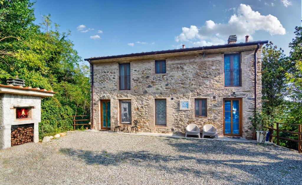 una casa de piedra con dos sillas delante en Dolce Vita in Tuscany B&B, en Capannori