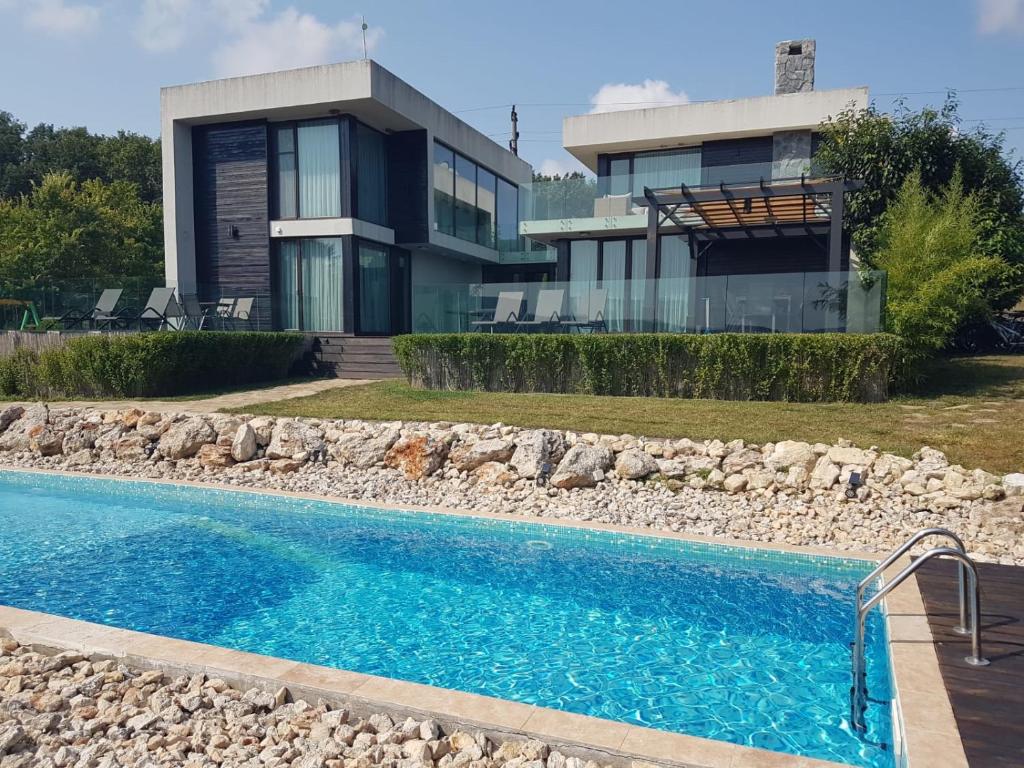 a house with a swimming pool in front of a house at Zlaten Briz Villa in Osenovo