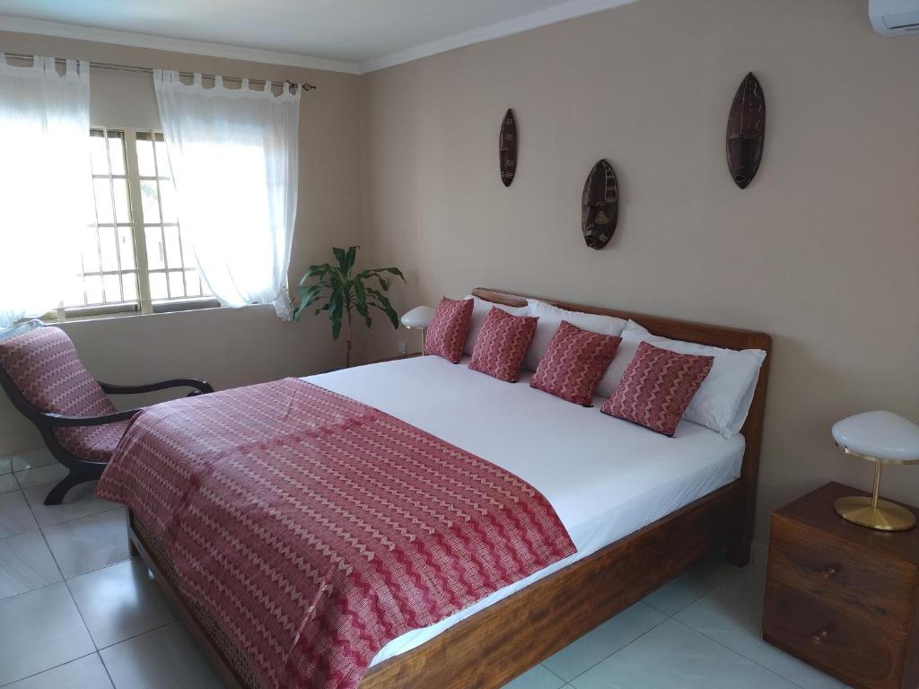 1 dormitorio con 1 cama con manta roja y blanca en Cole Street Guesthouse en Freetown