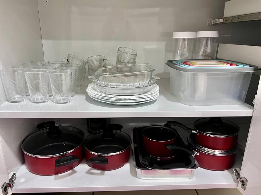 a white shelf with dishes and bowls and glasses at Nossa Casa, Sua Casa 02 - Excelente Localizacao in Paraty