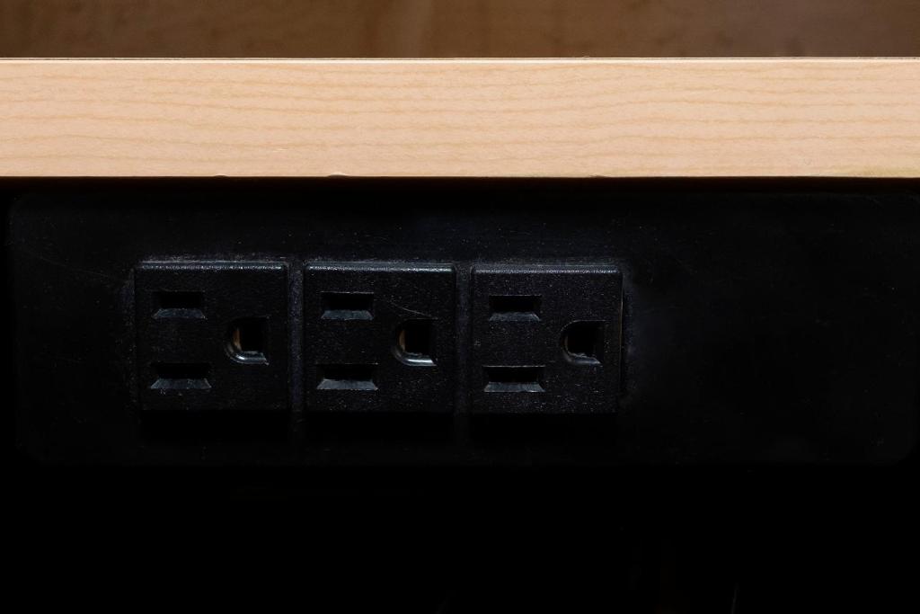 an electrical outlet on a table with a wooden counter top at Red Roof Inn Myrtle Beach Hotel - Market Commons in Myrtle Beach
